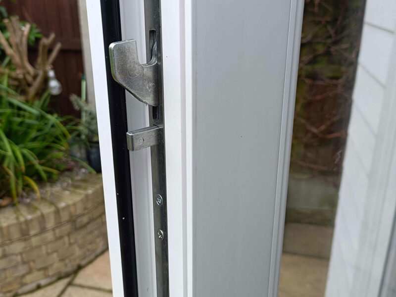 Multipoint door lock system engaged on a residential entry door, showing multiple locking points along the frame for enhanced security and weather sealing.