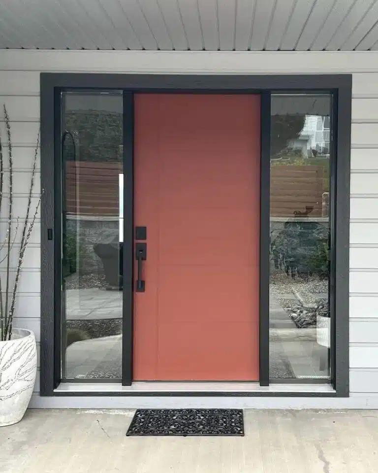 Red fiberglass entry door with glass side panels installed by Adera Windows & Doors
