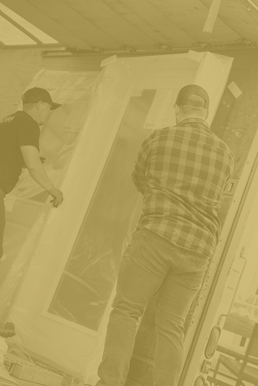 Two men from Adera install a new patio door at a home in the Okanagan