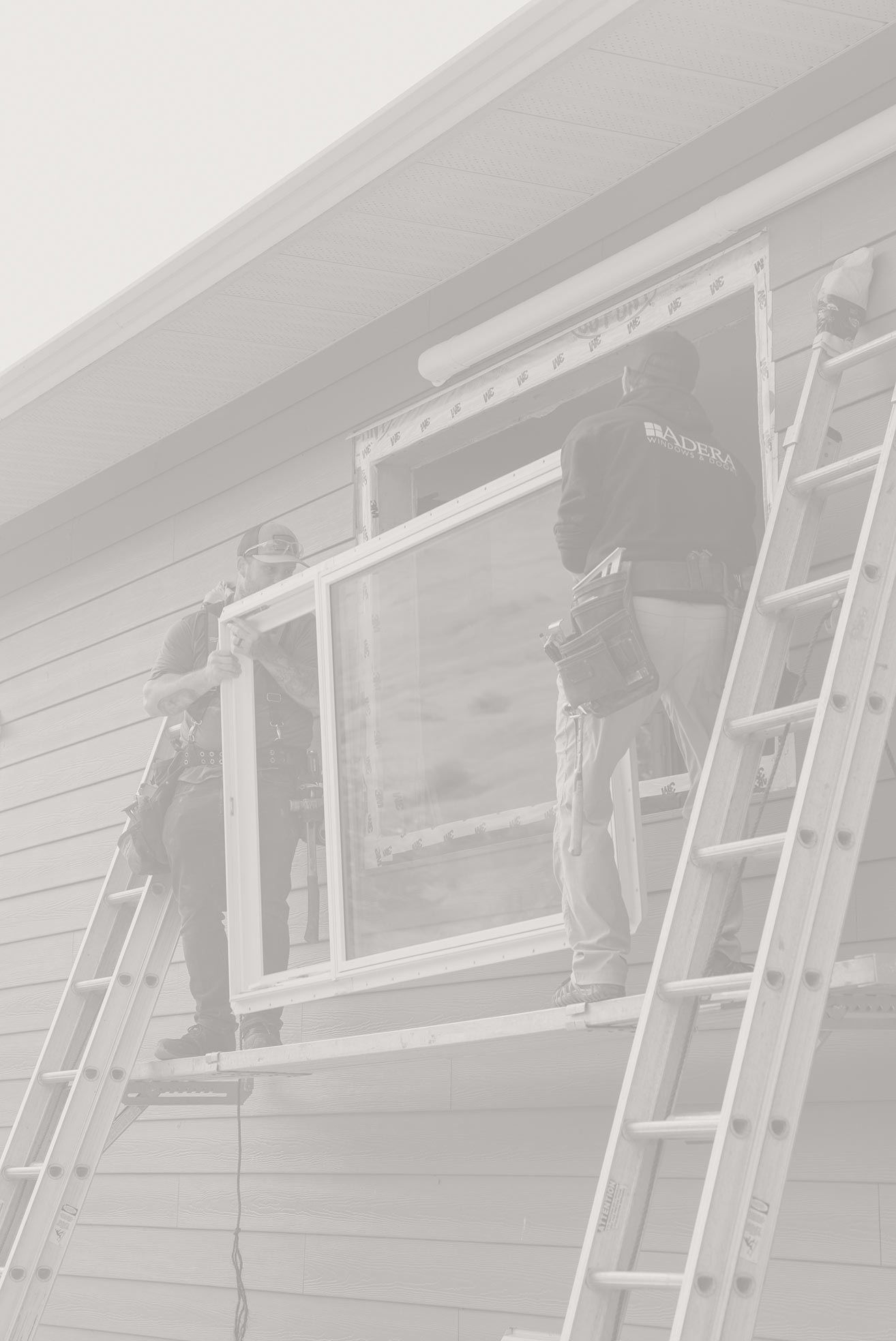 Two men from Adera install a new window on a home in Kelowna.