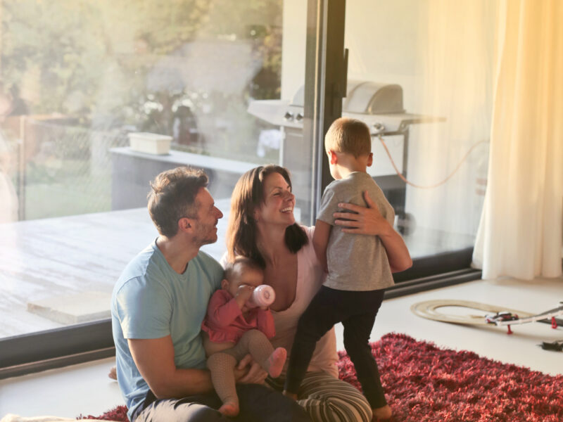Family enjoying the natural sunlight through a glass door.