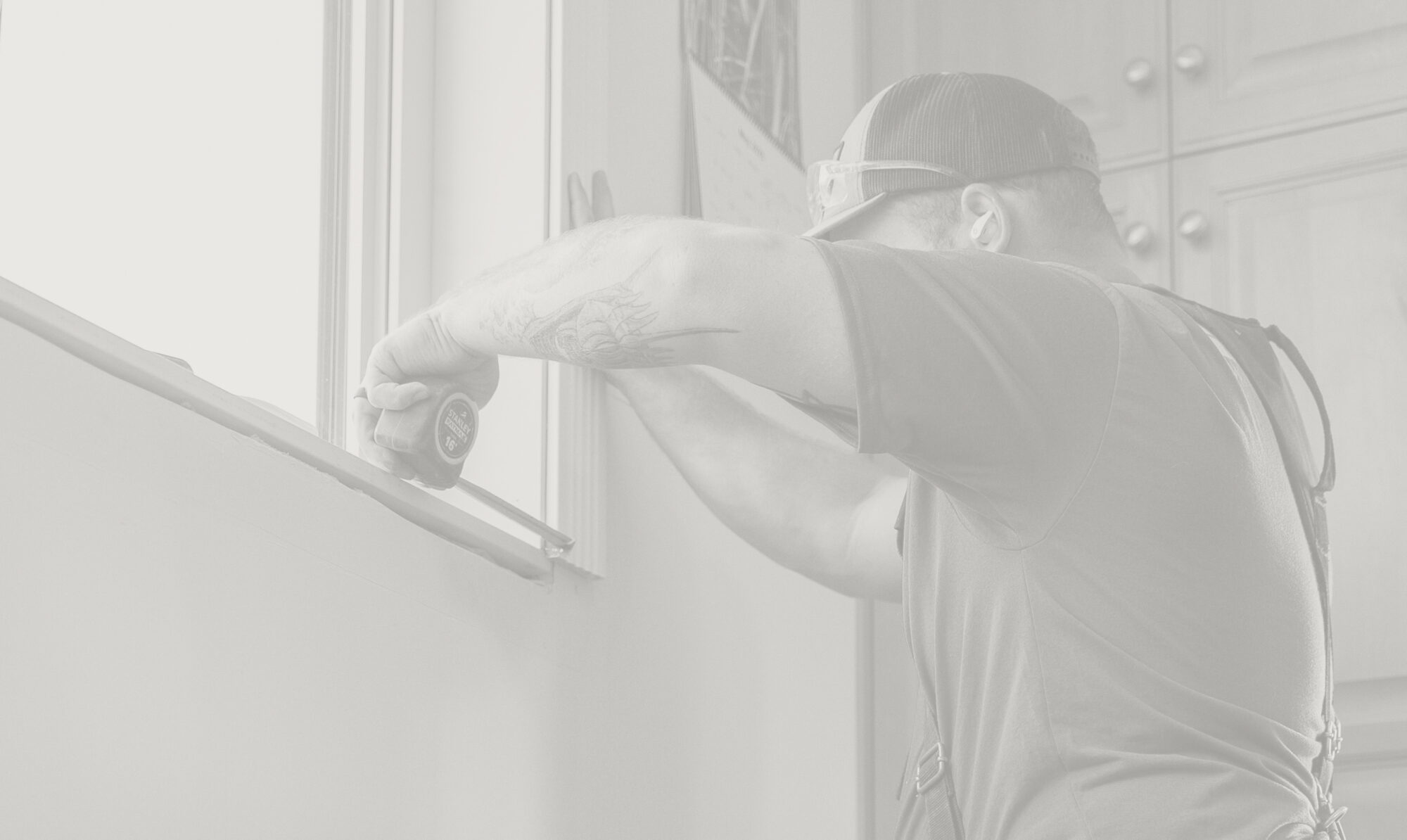 Man measures a window install on a residential home in the Okanagan.
