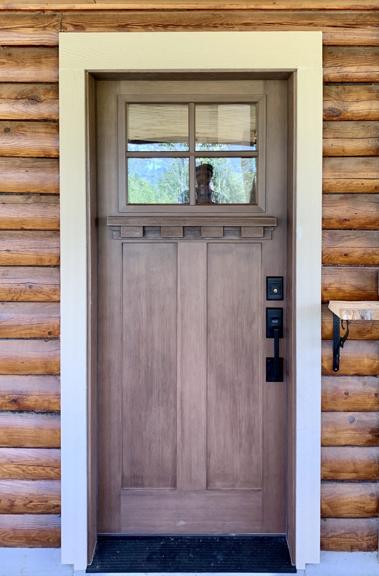 Modern wooden entry door on a log home.