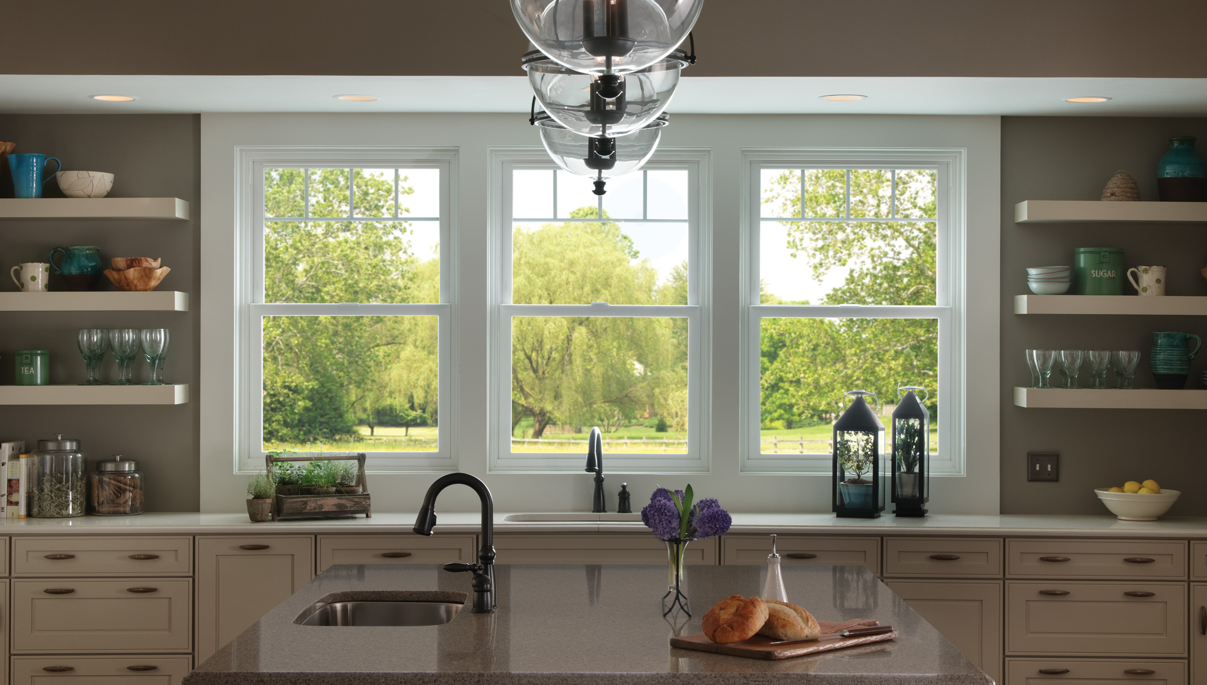 Large windows in a beautiful, modern kitchen, similar to work done by Adera in Kelowna.