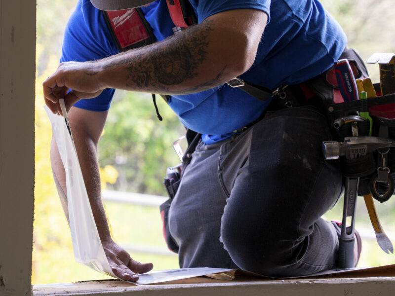 Adera technician applying flashing tape to a window sill during professional window installation in Coldstream, BC